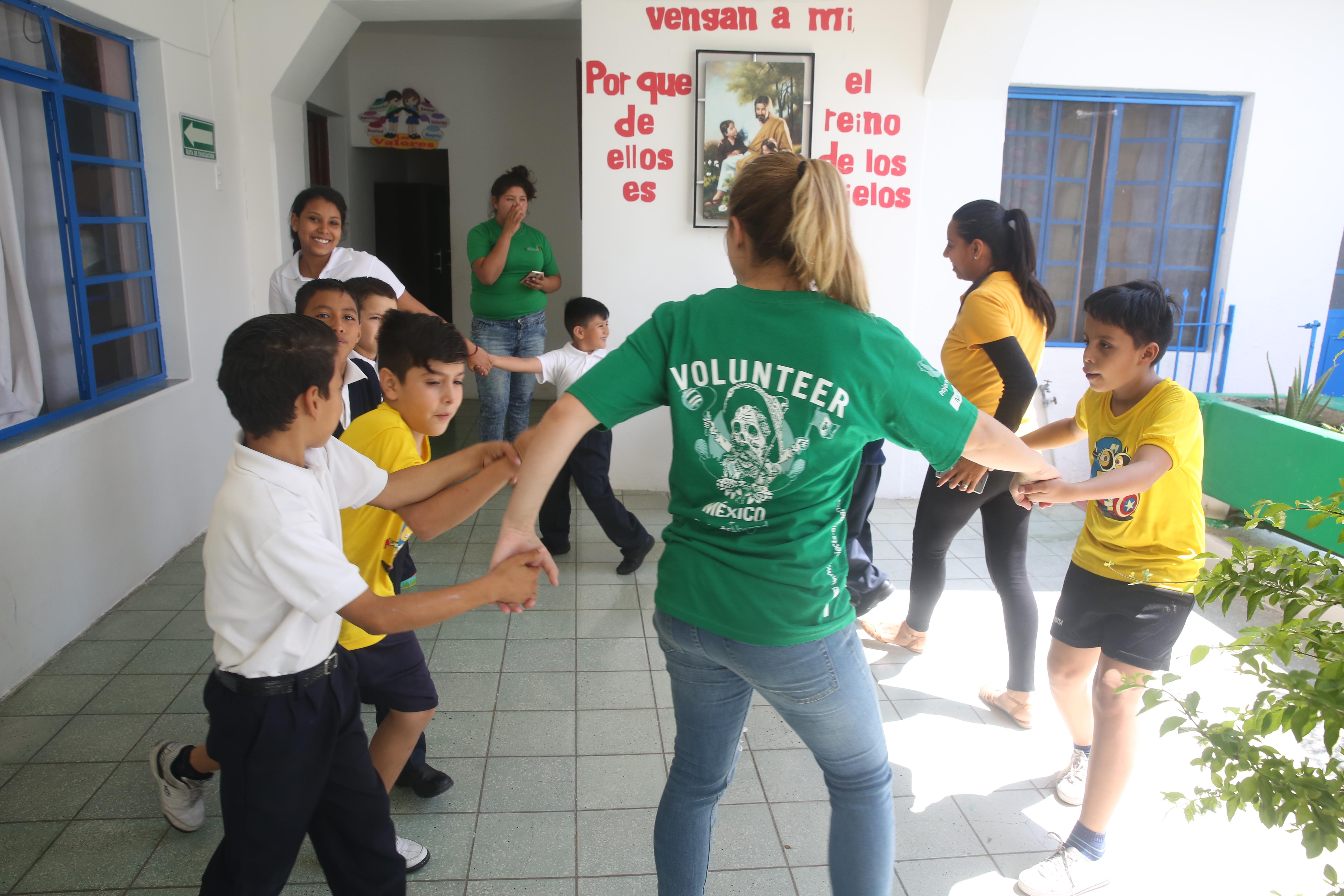 While learning Spanish in Mexico, a student also volunteers with Projects Abroad at a local school and leads fun activities. A student studying Spanish in Mexico volunteers in a local school with young children and plays educational games.